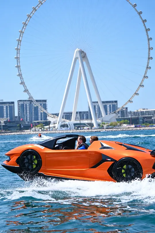 Orange Jet Car passing in front of Ain Dubai